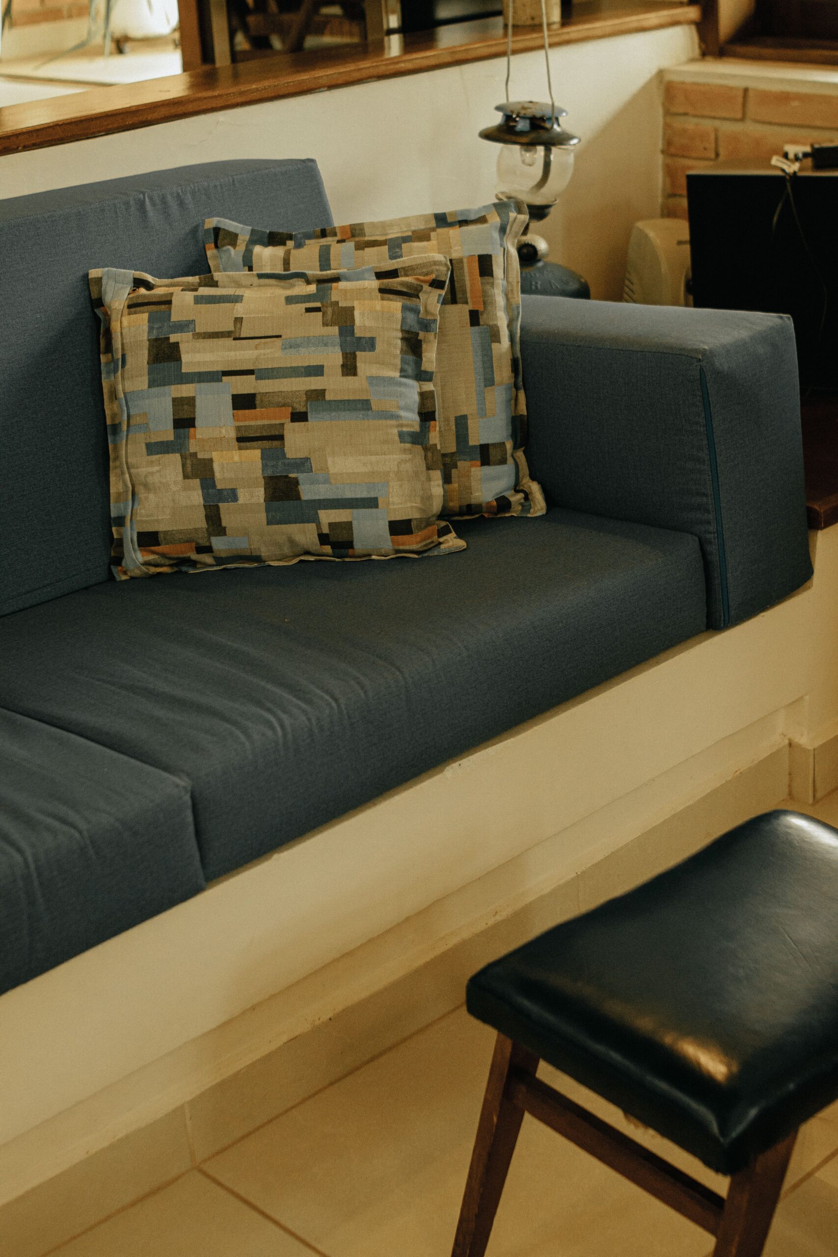 Home A comfortable blue sofa with abstract patterned cushions in a cozy indoor setting.